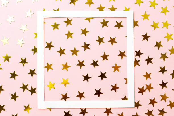 istock Golden confetti and white frame on a pink background, top view 1145872372