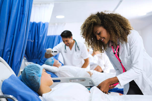 istock Afro american doctor who performs an exploration in a young patient before entering the surgery room. 1145874071