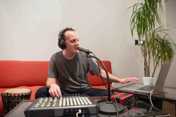 istock Professional musician recording midi keyboard in digital studio at home. He is surrounded with instruments and midi controller. Music production concept. 1145875123