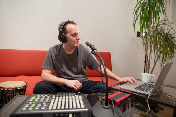 istock Professional musician recording midi keyboard in digital studio at home. He is surrounded with instruments and midi controller. Music production concept. 1145875124