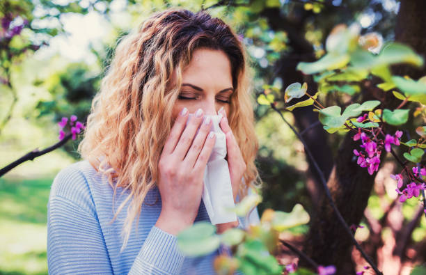 istock Cold and flu. Woman blowing her nose with a tissue 1145875346