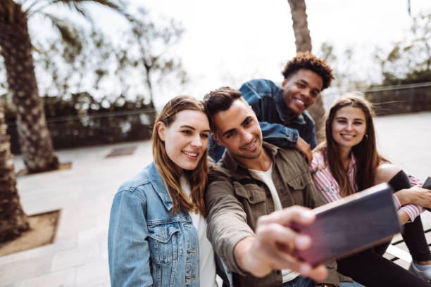 istock friends taking selfie in barcelona sitting on a bench 1145875654
