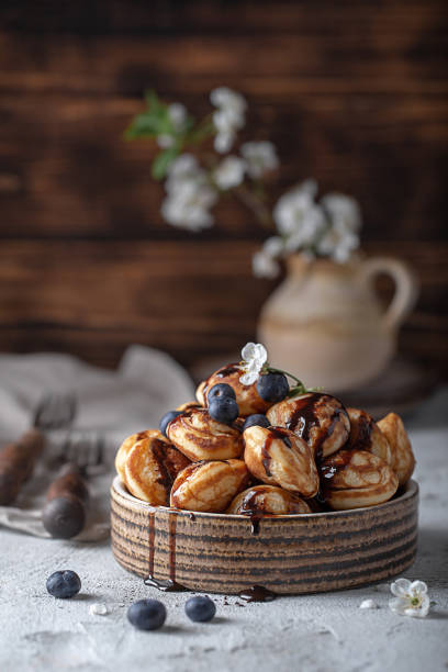 pancakes with chocolate and blueberries pancakes with chocolate and blueberries in a ceramic bowl apple cinnamon pancake stock pictures, royalty-free photos & images