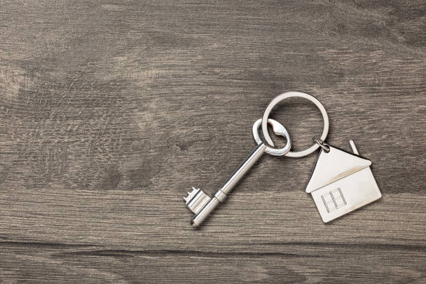 istock House keychain and key on wooden table with copy space 1145876110