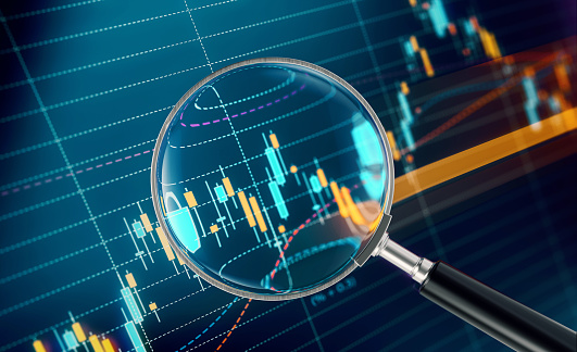 Magnifier focusing on a financial data analysis graph. Selective focus. Horizontal composition with copy space.