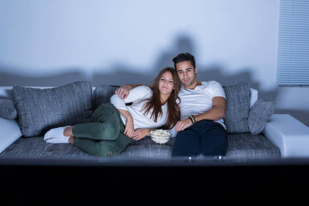 istock Young couple watching a movie at home 1145877587