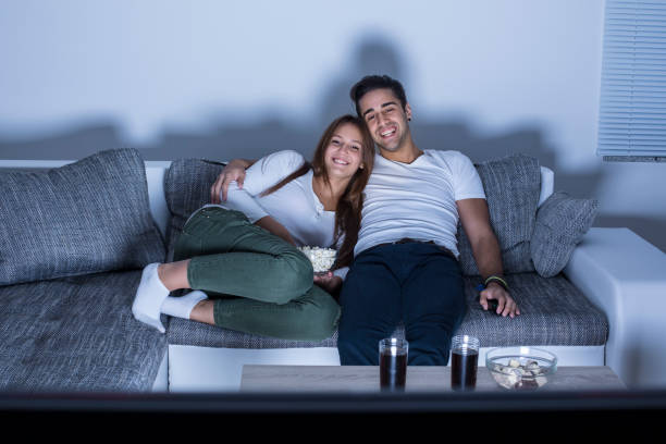 istock Young couple watching a movie at home 1145877661