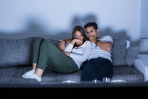 istock Young couple watching a movie at home 1145877687