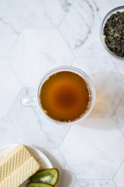 istock Green tea with jasmine in a transparent mug on a light background. Vertical orientation 1145882618