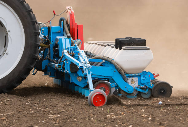 istock Farmer with tractor seeding  crops at agricultural field 1145884044