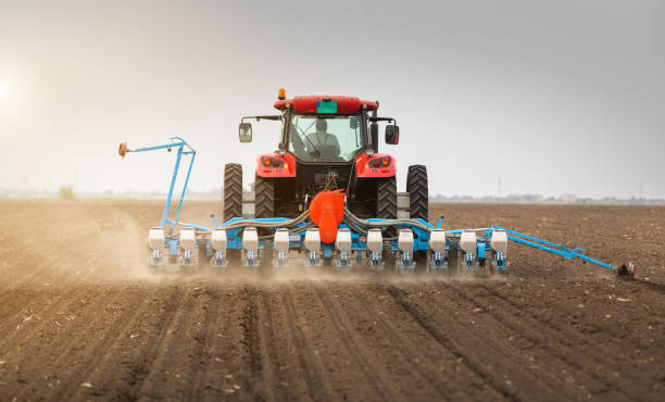 istock Farmer with tractor seeding  crops at agricultural field 1145884104
