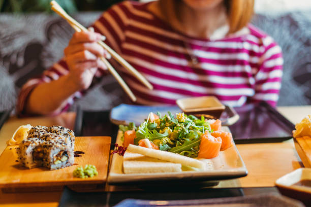istock Sushi. Girl eating sushi 1145885456