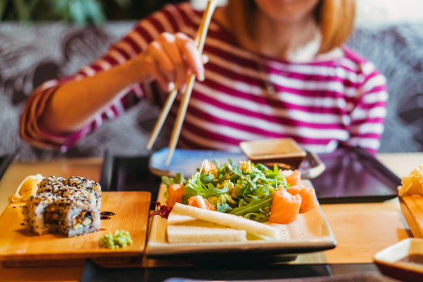 istock Sushi. Girl eating sushi 1145885611