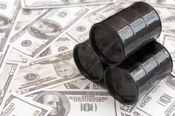 Photo of Barrels of oil against the background of American dollars
