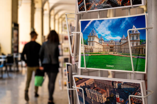 Turin, Italy - April 20, 2019 : Postcards of Turin in a local shop under the arches of Po street with tourist passing by