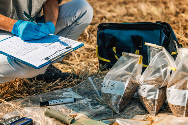 土壌検査女性瀬戸際フィールドでメモを取る - environmental assessment ストックフォトと画像