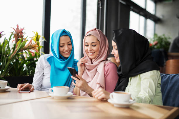 Group of islamic girls using smart phone Group of islamic girls using smart phone arabian girl stock pictures, royalty-free photos & images