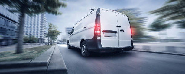 istock White transporter driving through the city at night 1145899966