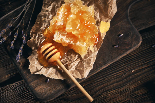 istock Honeycomb and bamboo dipper on wooden table 1145900042