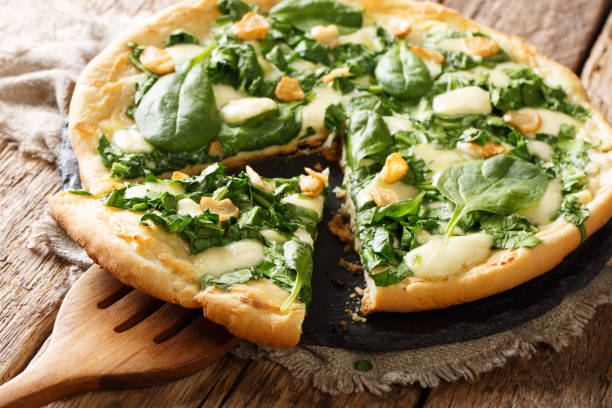 istock Healthy white pizza with spinach, garlic and ricotta cheese and mozzarella close-up. horizontal 1145900968