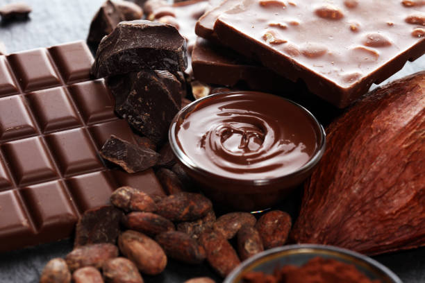 istock Melting chocolate or melted chocolate with a chocolate swirl and stack, chips and powder on black 1145901002