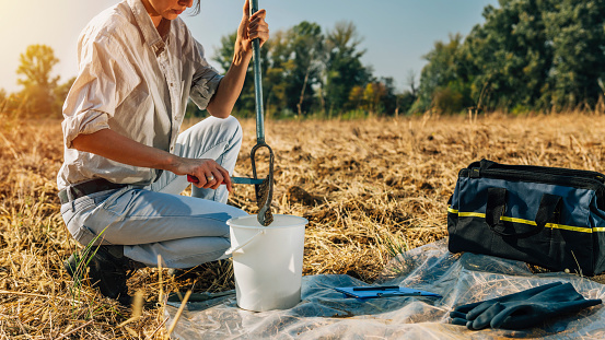 Soil Sampling. Female agronomist taking sample with soil probe sampler. Environmental protection, organic soil certification, research