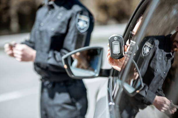 policeman checking woman driver for alcohol intoxication - intoxication imagens e fotografias de stock