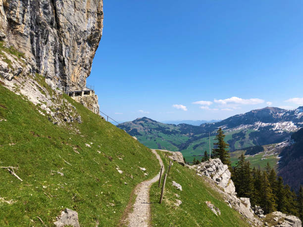 penhasco de äscher ou äscher-felsen (aescher-felsen ou ascher-felsen) na escala de montanha de alpstein e na região de appenzellerland - ascher - fotografias e filmes do acervo