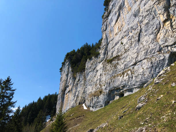 penhasco de äscher ou äscher-felsen (aescher-felsen ou ascher-felsen) na escala de montanha de alpstein e na região de appenzellerland - ascher - fotografias e filmes do acervo