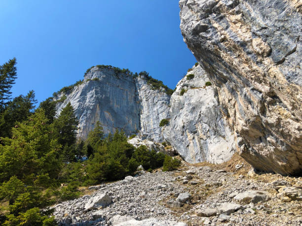 penhasco de äscher ou äscher-felsen (aescher-felsen ou ascher-felsen) na escala de montanha de alpstein e na região de appenzellerland - ascher - fotografias e filmes do acervo