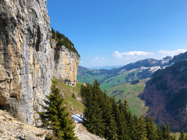 penhasco de äscher ou äscher-felsen (aescher-felsen ou ascher-felsen) na escala de montanha de alpstein e na região de appenzellerland - ascher - fotografias e filmes do acervo