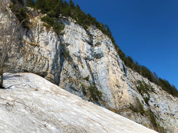 penhasco de äscher ou äscher-felsen (aescher-felsen ou ascher-felsen) na escala de montanha de alpstein e na região de appenzellerland - ascher - fotografias e filmes do acervo