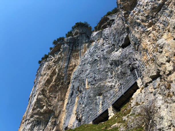 äscher cliff o äscher-felsen (aescher-felsen o ascher-felsen) en la cordillera de alpstein y en la región de appenzellerland - ascher fotografías e imágenes de stock