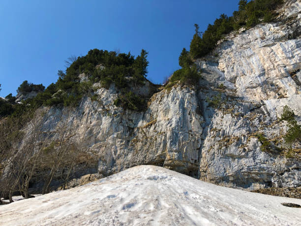 penhasco de äscher ou äscher-felsen (aescher-felsen ou ascher-felsen) na escala de montanha de alpstein e na região de appenzellerland - ascher - fotografias e filmes do acervo