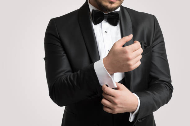 mann in tuxedo trägt manschettenknöpfe - smoking man stock-fotos und bilder