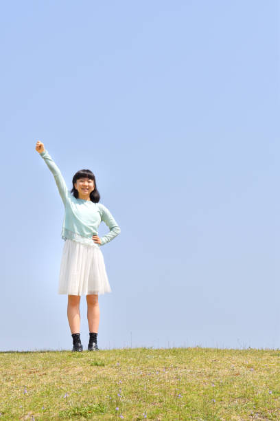 Japanese girl striking a victory pose in the blue sky
