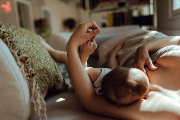 Motherhood Breastfeeding in the morning tranquil scene stock pictures, royalty-free photos & images