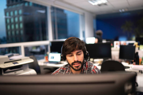 empregado que trabalha com auriculares no callcenter do escritório - service desk - fotografias e filmes do acervo