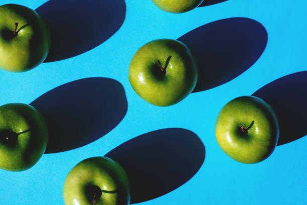 istock Group of green apples on blue background 1145916646