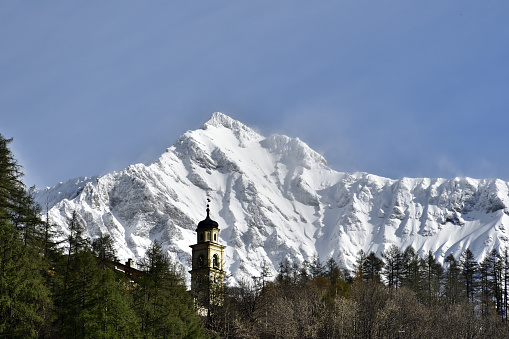 Primolo is a small group of house in Chiesa in Valmalenco town. The view shows Primolo and his church with Valmalenco mounting range, with fresh snow on the back. In this mounting range are present the following peaks: 