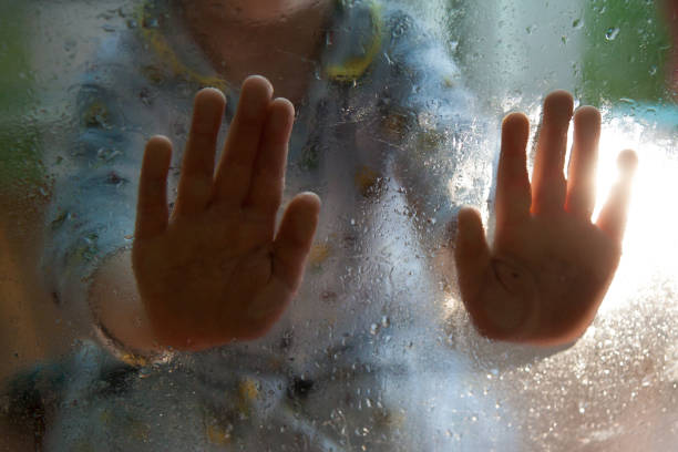 istock baby palms are touching a wet glass with drops 1145922764