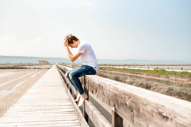 istock Young man sitting on a wooden fence 1145925687