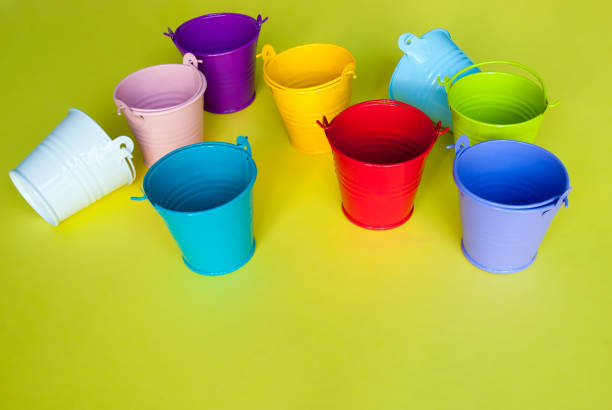 istock Colorful empty buckets on yellow background 1145925742
