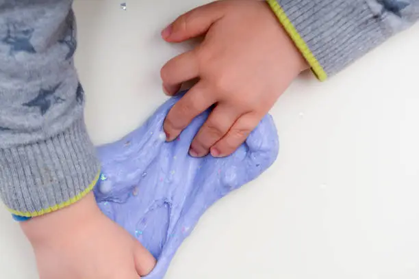 Photo of Child playing with slime, a trendy home crafting activity