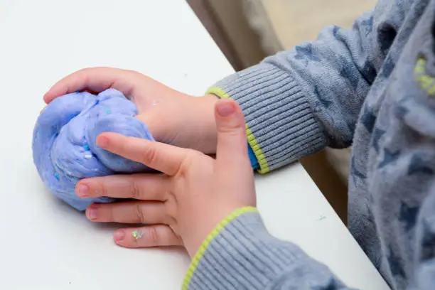 Photo of Child playing with slime, a trendy home crafting activity