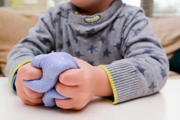 Photo of Child playing with slime, a trendy home crafting activity