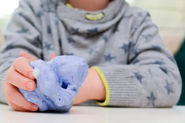Photo of Child playing with slime, a trendy home crafting activity