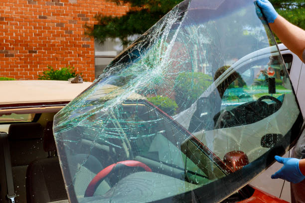 os trabalhadores especiais do carro quebrado do pára-brisa tomam do pára-brisa de um carro no auto serviço - windshield - fotografias e filmes do acervo