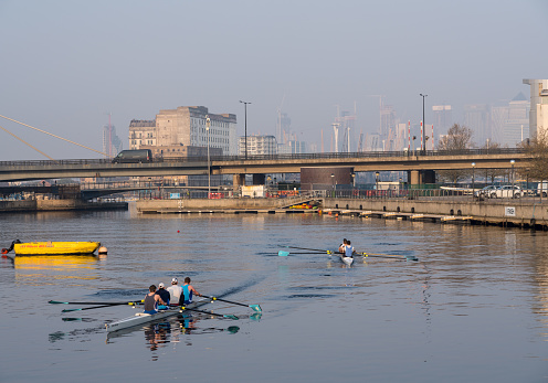 LONDON, UK - 17 APRIL 2019: Rowing team train by London City Airport on misty morning at sunrise