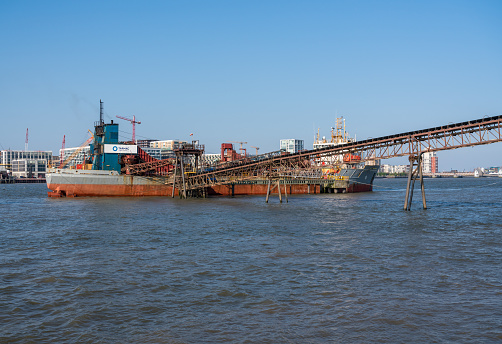 LONDON, UK - 21 APRIL 2019: Offloading of sand and aggregate gravel in Angerstein Wharf near Greenwich in London